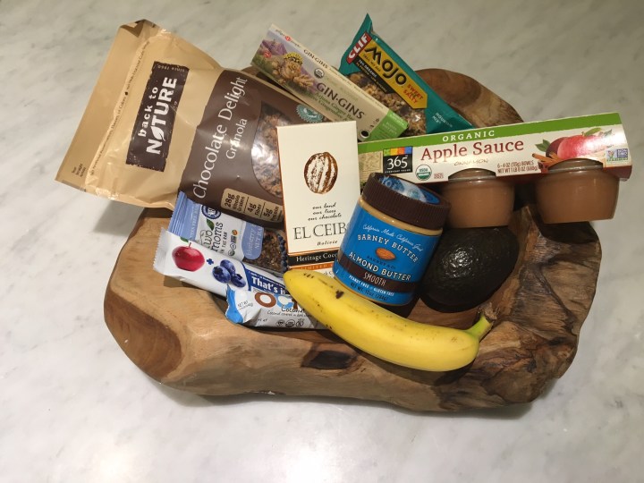 Foods in photo include: 1. Back to Nature- Chocolate Delight Granola 2. Two Moms in the Raw- Blueberry 3. That's It- Apple and Blueberry 4. Ocho- coconut 5. El Ceibo 6. Gin-Gins Arjuna Ginger Bar 7. Barney Butter- Almond Butter 8. Mojo Trail Mix bar 9. Cinnamon Apple Sauce 10. Banana 11. Avocado 
